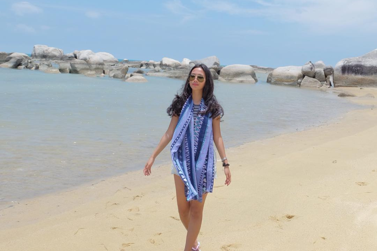 wisatawan berjalan di pantai penyabong